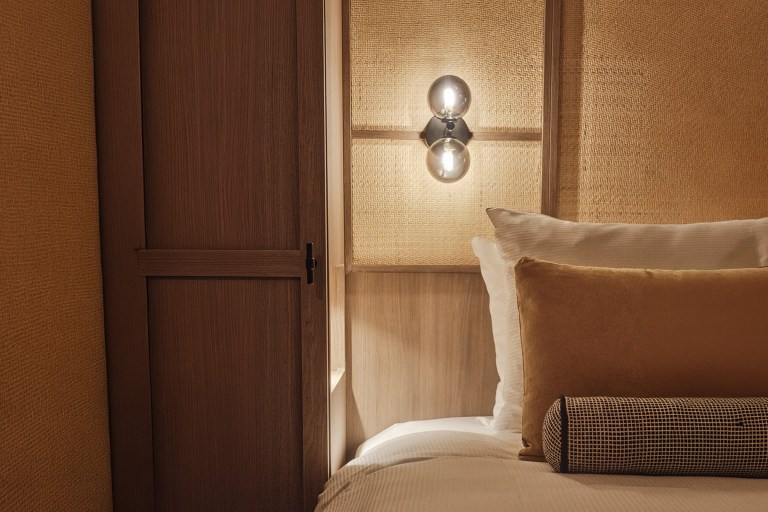 Bedroom detail of the Jan Luyken Amsterdam suite featuring custom wall panelling, lighting and bespoke hospitality interior design by Studio Hank.